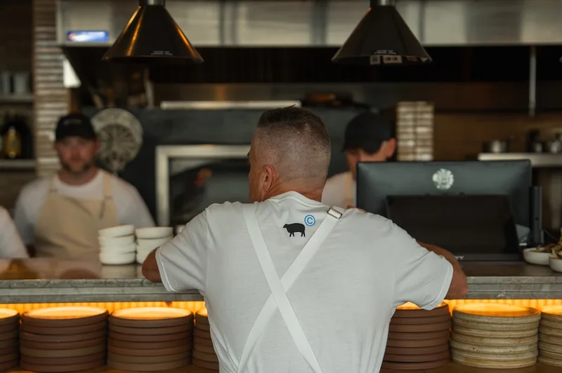 Chefs working at the pass in front of the open hearth at Sheep